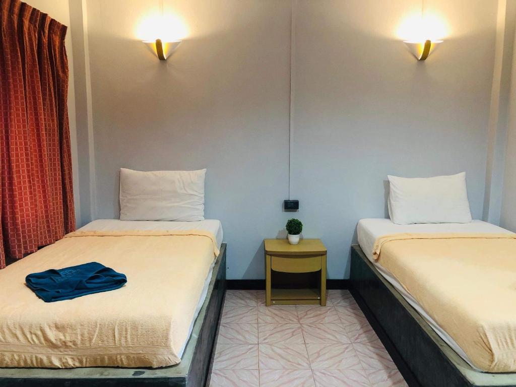 2 posti letto in una piccola camera con tavolo di Lovely Lanta Resort a Ko Lanta