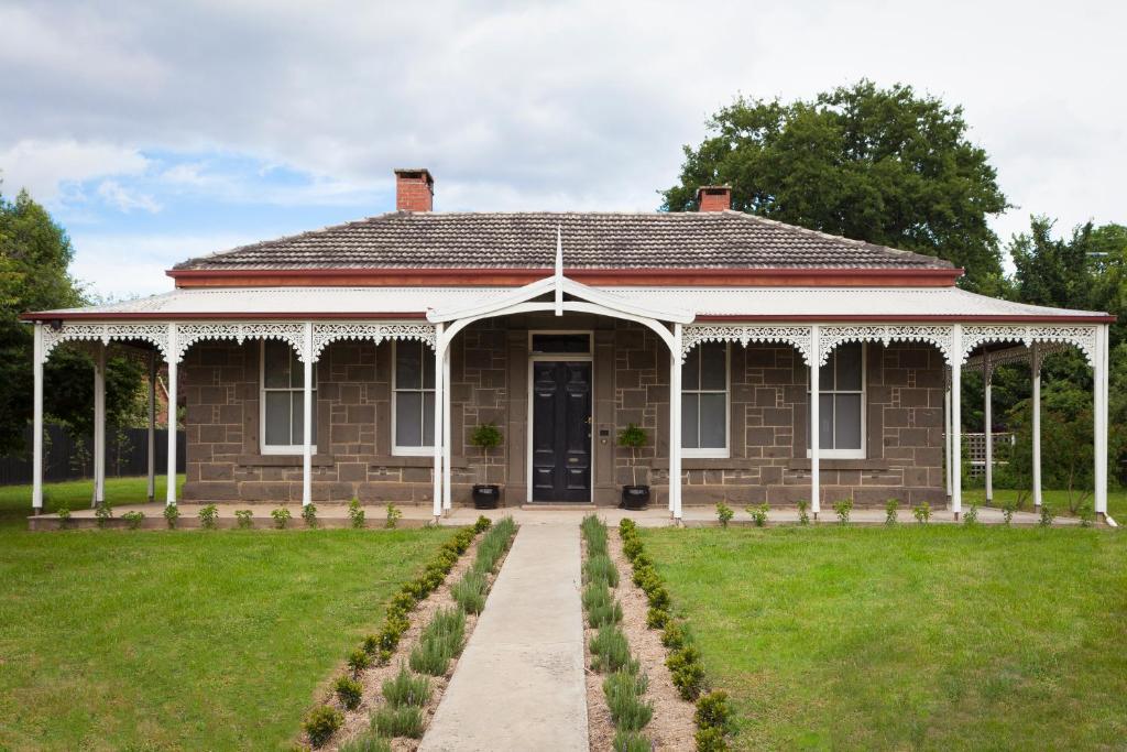 a brick house with a porch and a lawn at The Manse on Ebden in Kyneton