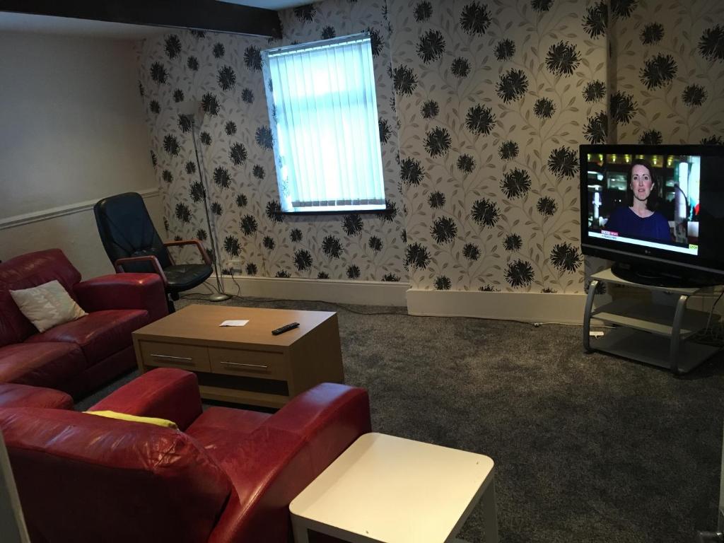 a living room with a couch and a flat screen tv at No1 Decent Home in Dukinfield