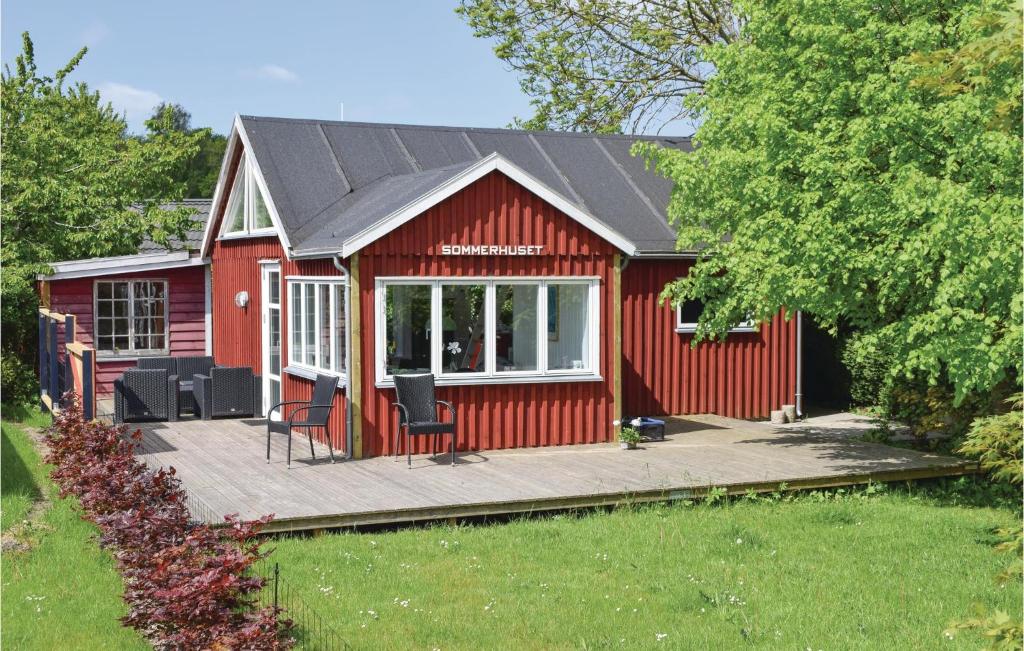 een rood gebouw met een terras in de tuin bij Awesome Home In Hornslet With Wifi in Hornslet