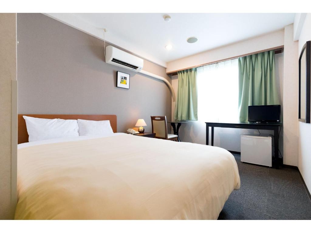 Postel nebo postele na pokoji v ubytování Hotel Yutaka Wing
