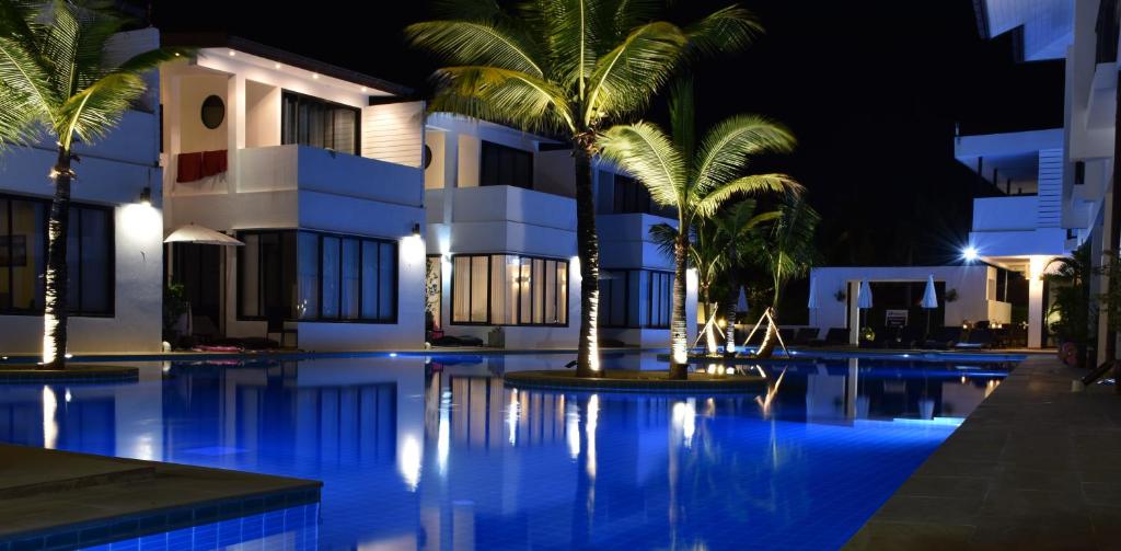 a swimming pool in front of a hotel at night at Sai Naam Lanta Residence SHA Plus in Ko Lanta