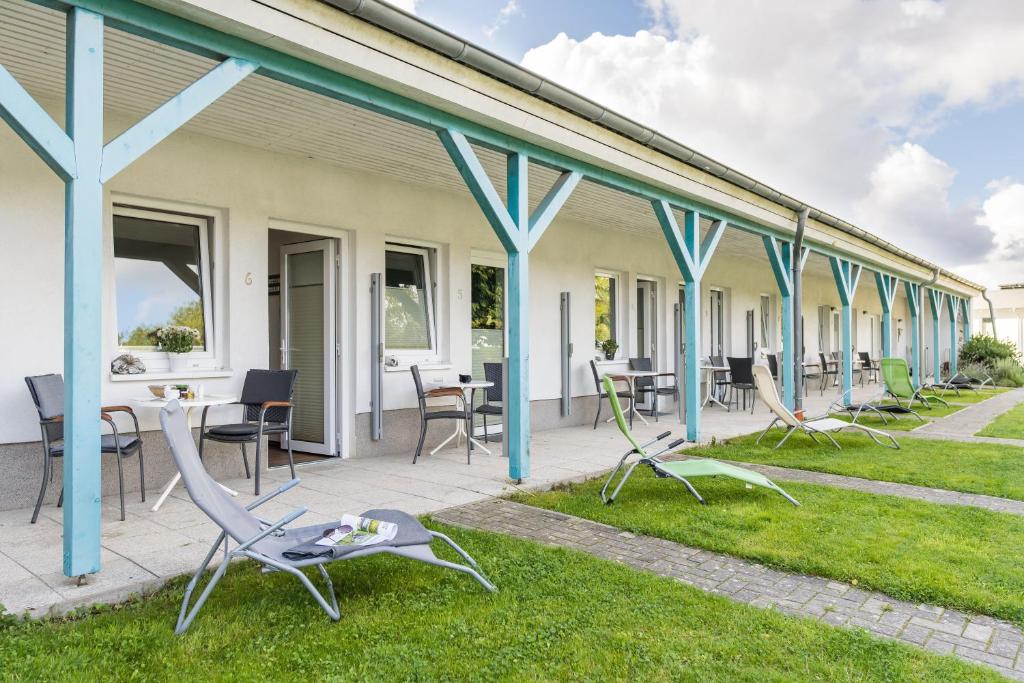 een rij huizen met stoelen en tafels op het gras bij Pension Kreidefels in Sassnitz