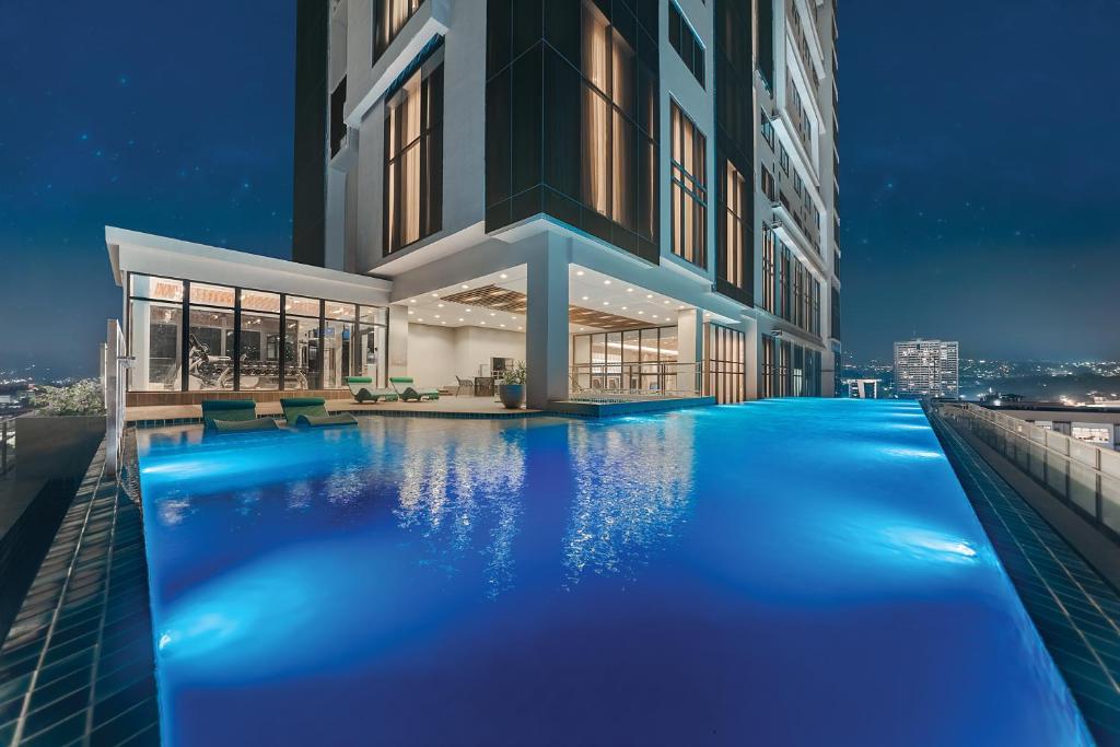 uma piscina em frente a um edifício à noite em Citadines Cebu City em Cebu