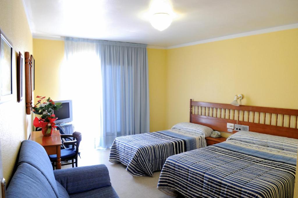 サン・カルラス・デ・ラ・ラーピタにあるPlaça Vellaのベッド2台とソファが備わるホテルルームです。