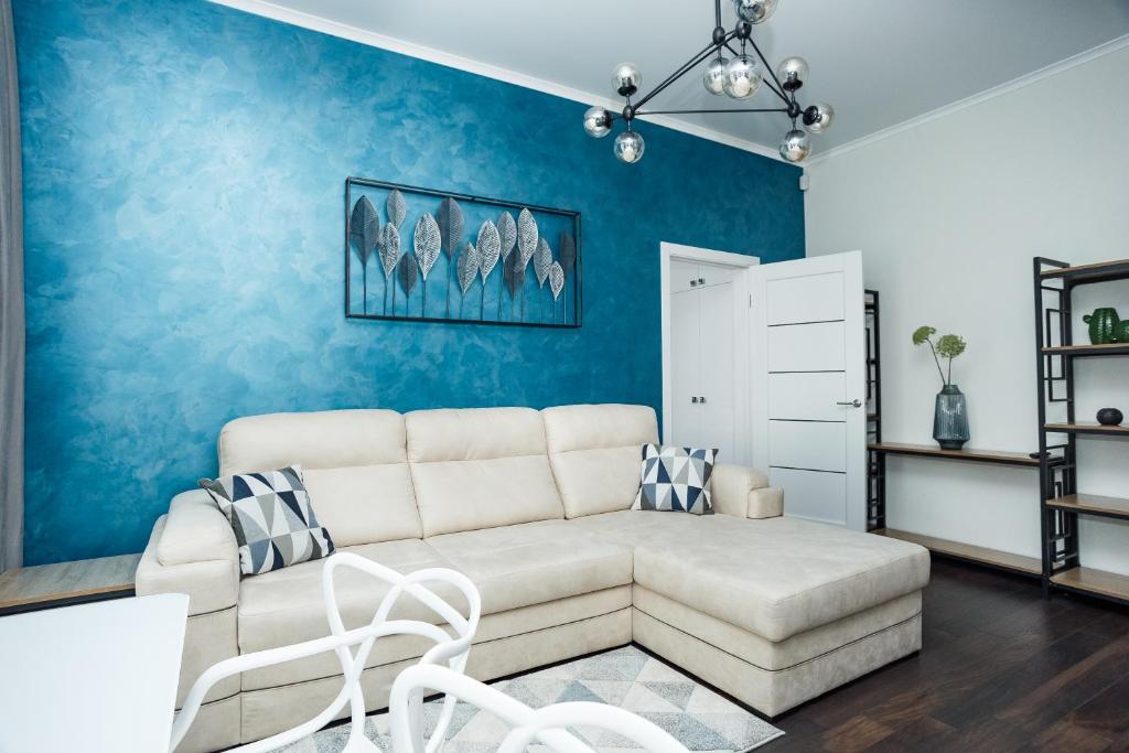 sala de estar con sofá y pared azul en Квартира в центре для гурманов стиля, en Cherníhiv