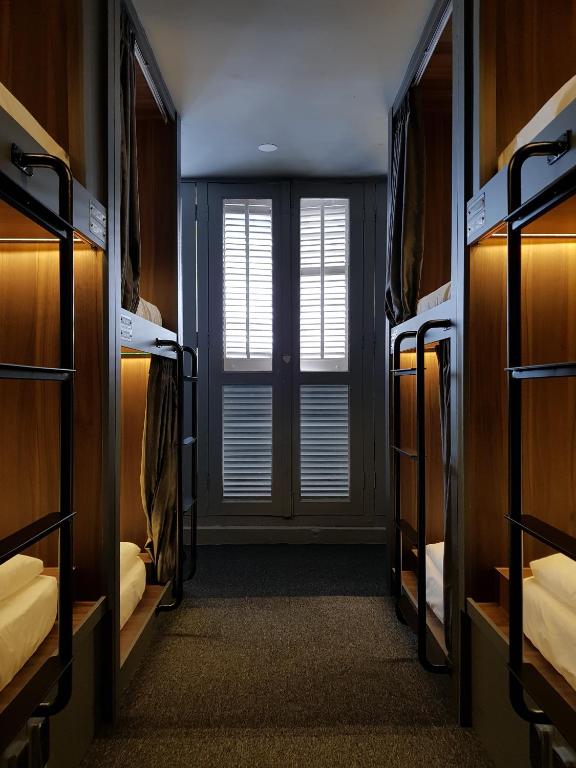 a room with four bunk beds with a window at Wink at McCallum Street in Singapore