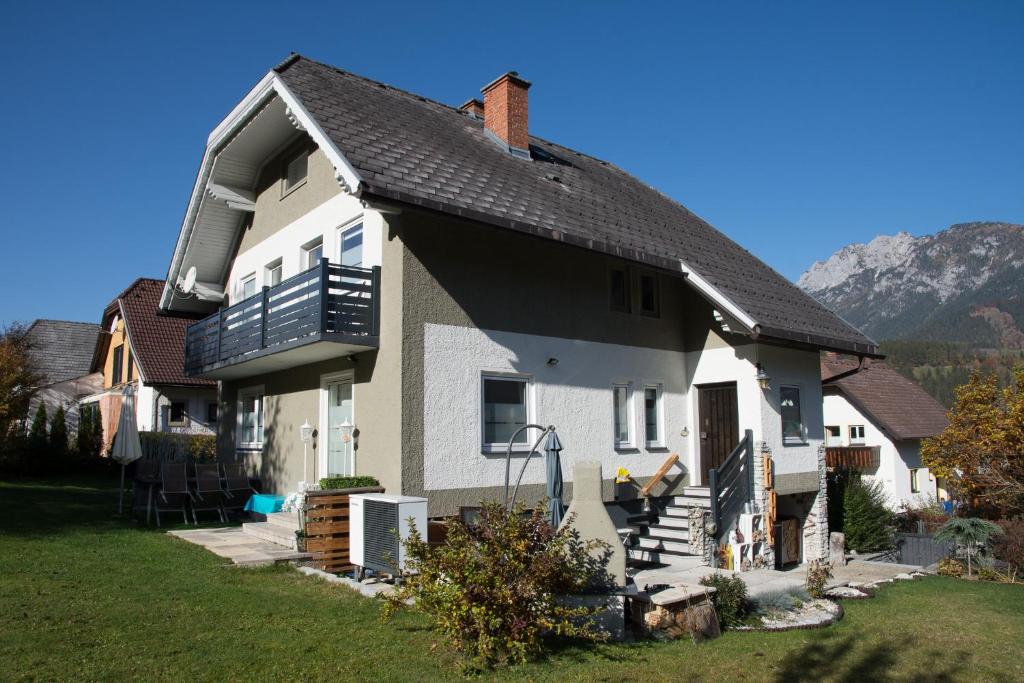 een wit huis met een zwart dak bij apartHAUS in Haus im Ennstal