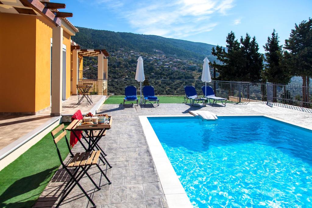 a swimming pool with chairs and a table next to a house at Ble on Blue in Athanion
