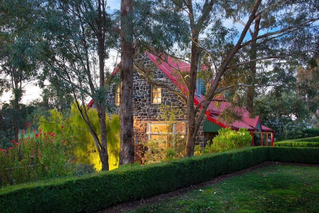 a house with a red roof in a garden at Bluegums Retreat in Hepburn Springs