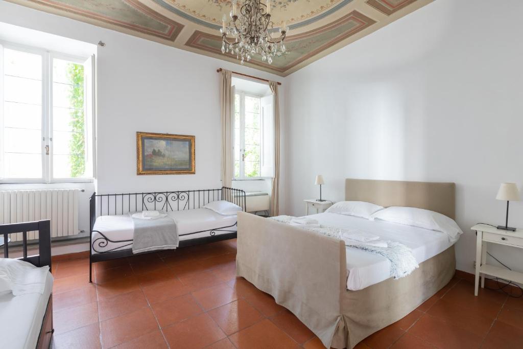 ein weißes Schlafzimmer mit 2 Betten und einem Kronleuchter in der Unterkunft The Right Place 4U Roma Campo de fiori Apartment La Quercia in Rom