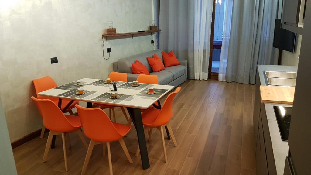 a living room with a table and orange chairs at Orange Fox Cervinia apartment Vda Vacanze in Vetta CIR 0185 in Breuil-Cervinia