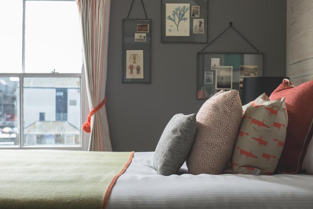 a bedroom with a bed with pillows and a window at Chainlocker in Falmouth