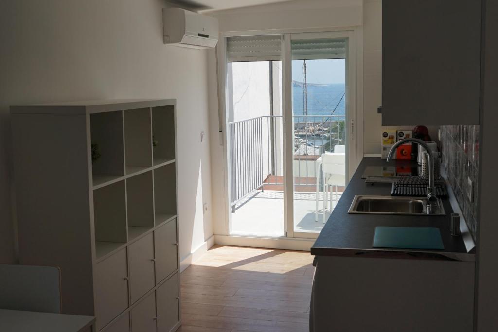 a kitchen with a sink and a door to a balcony at Pescadors Apartamentos by TRG in Benidorm