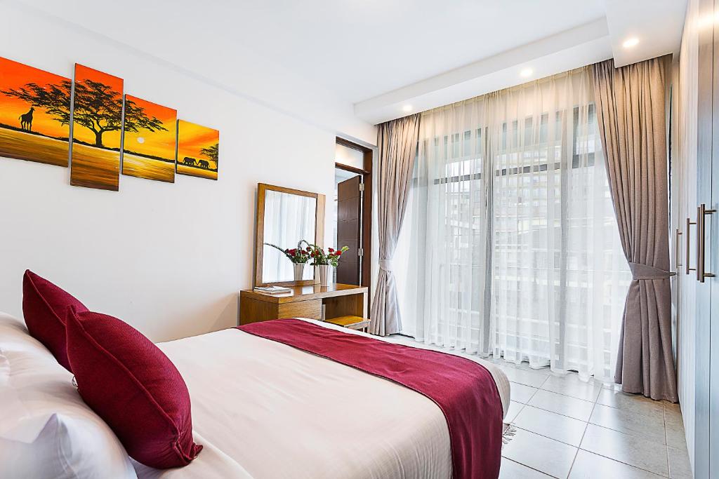 Postel nebo postele na pokoji v ubytování L'Aziz Suites