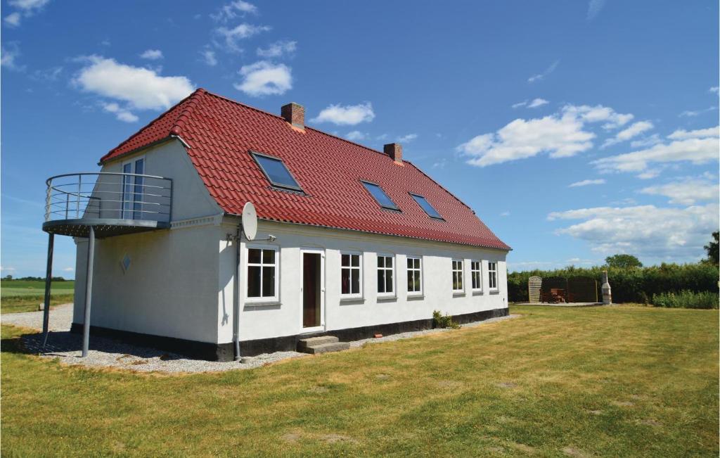 uma casa branca com um telhado vermelho num campo em 3 Bedroom Gorgeous Home In Harpelunde em Harpelunde
