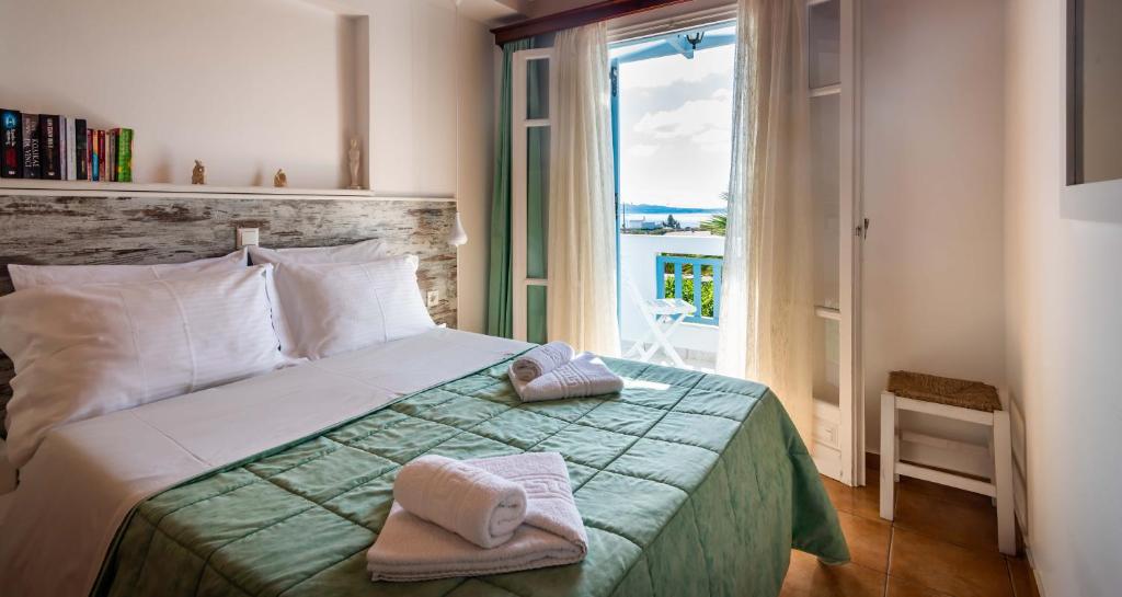 a bedroom with a bed with towels on it at Orizontes Boutique Studios in Adamantas