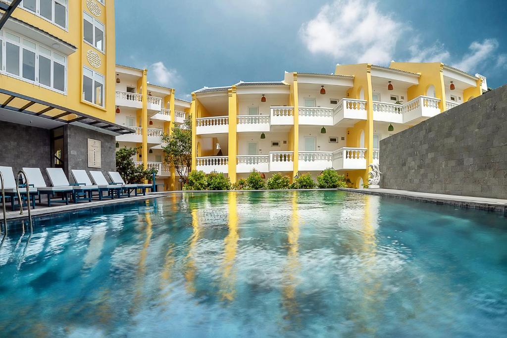 a swimming pool in front of a building at Hoi An Aurora Riverside Hotel and Spa in Hoi An