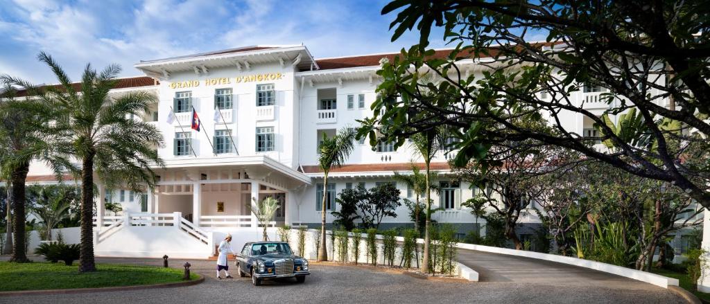 
a white car parked in front of a house at Raffles Grand Hotel d'Angkor in Siem Reap
