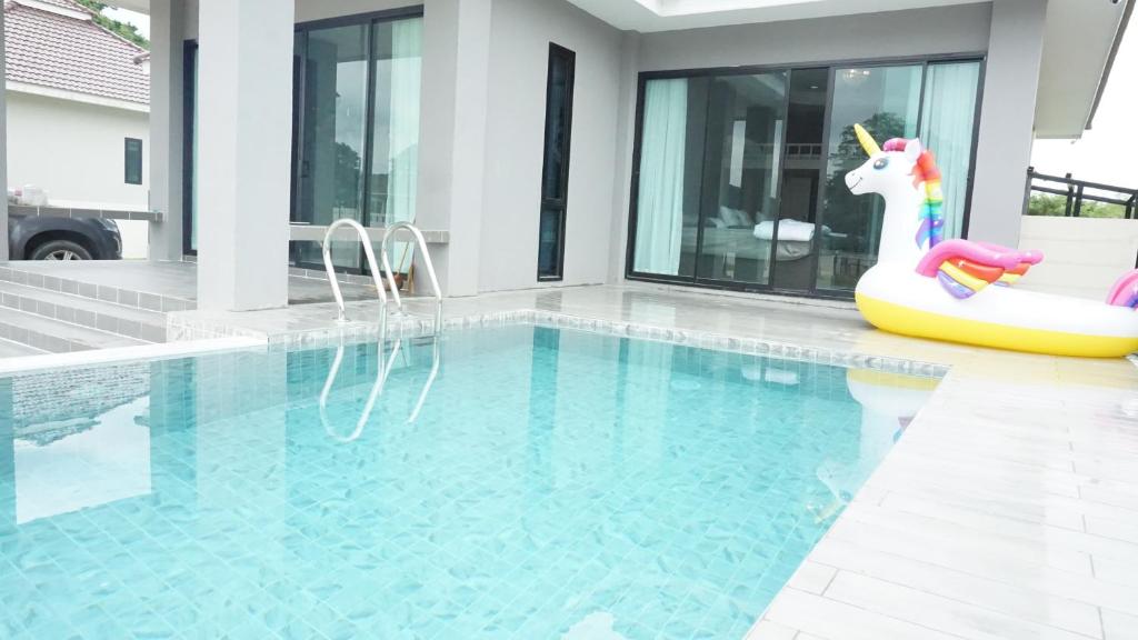 una piscina con un unicornio flotando en una casa en The Chaleur Pool Villa en Sattahip