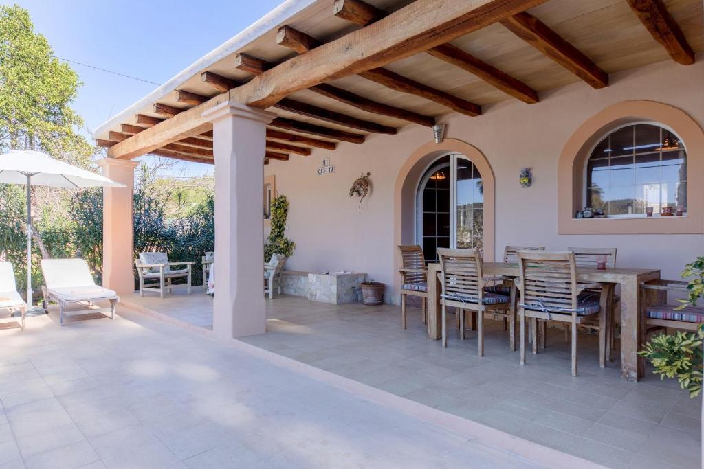 a patio with a wooden pergola and a table and chairs at Mi Casita in Ses Salines