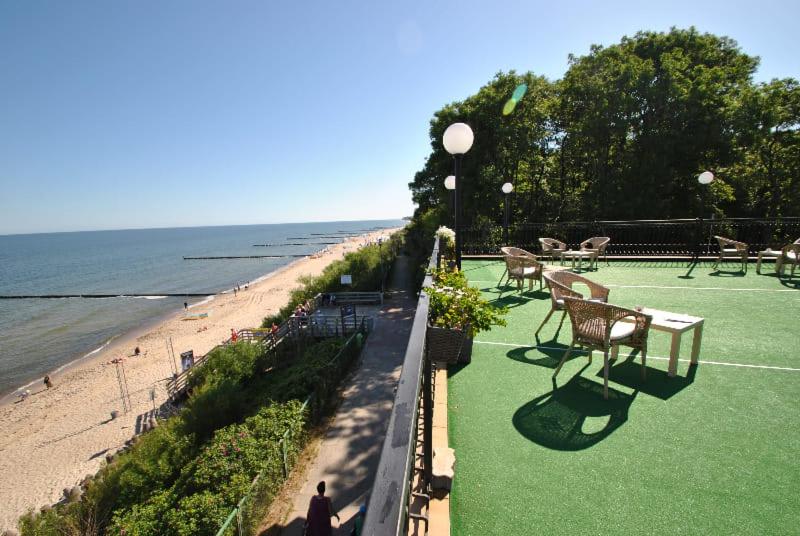 a person walking on a lawn near the beach at Pensjonat Kaszubianka in Ustronie Morskie