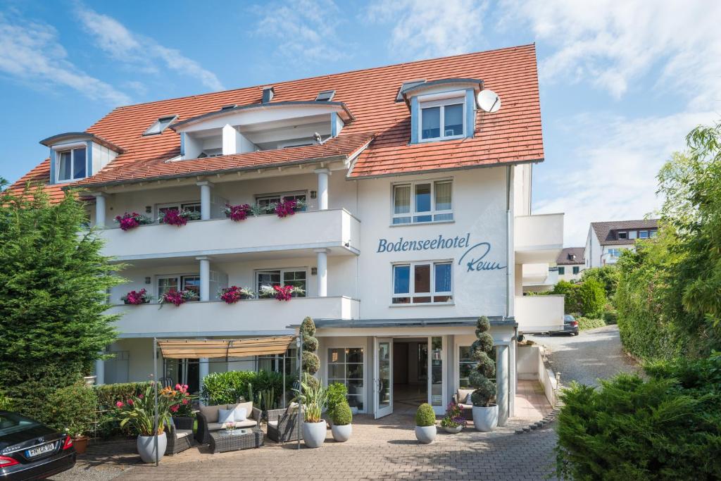 a large white building with a red roof at Bodenseehotel Renn in Hagnau