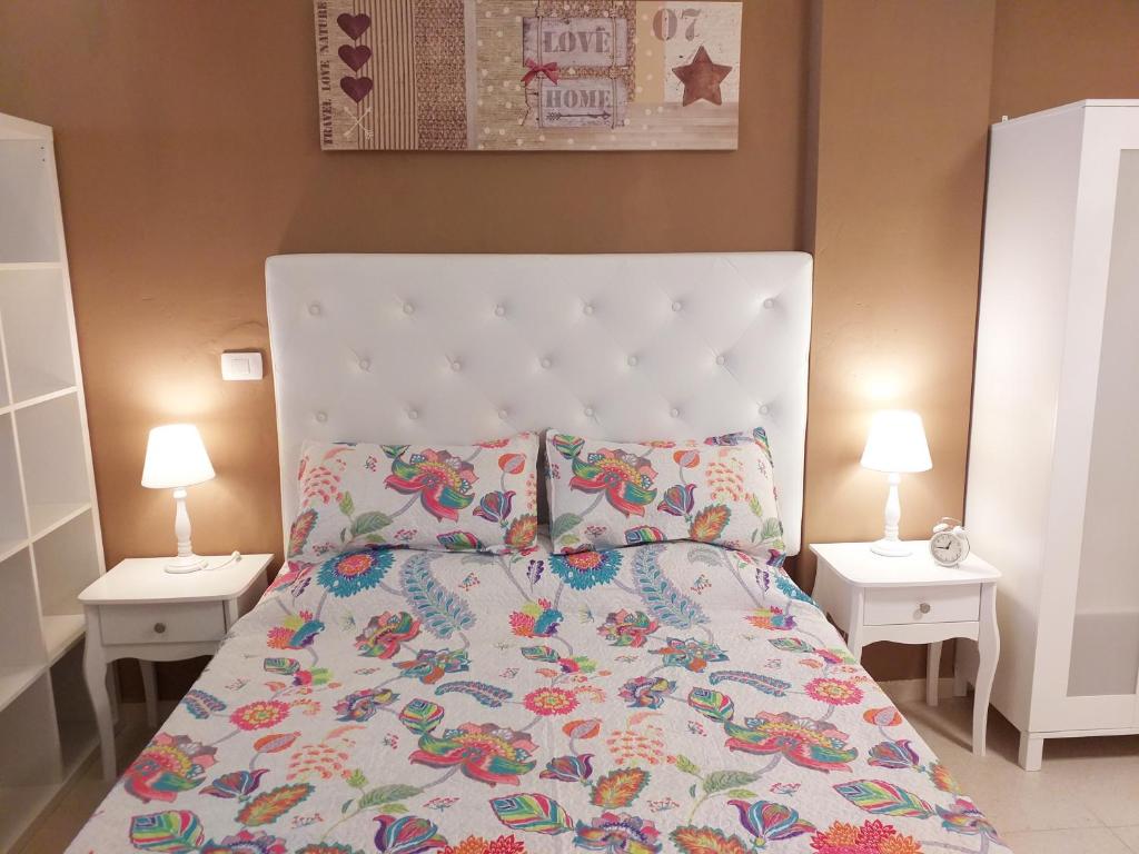 ein Schlafzimmer mit einem großen Bett mit zwei Nachttischen in der Unterkunft Apartamento TRISTANA in Vecindario