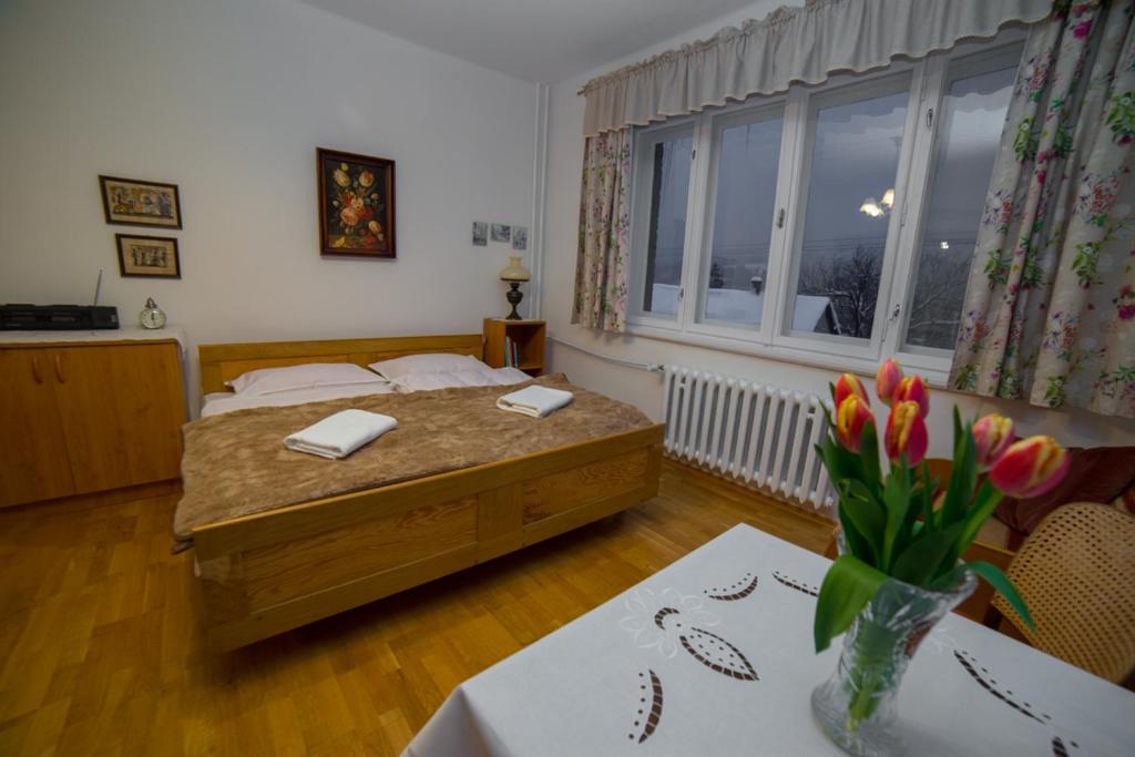 1 dormitorio con 1 cama y 1 mesa con flores en Agroturystyka Na Dzielnicach en Wisła