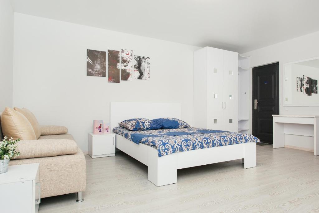um quarto branco com uma cama e um sofá em апартаменты возле Лавины.Новый дом. 1 этаж em Sumy