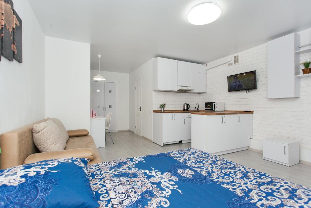 Una habitación blanca con una cama y una cocina. en Апартаменты возле ТЦ Лавина 1 этаж, en Sumy