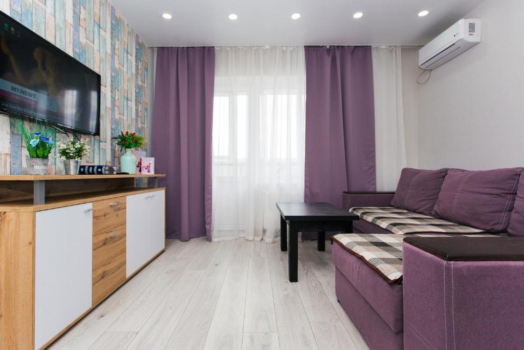 スームィにあるVIP Apartments Faraon Centrの紫色のソファとテーブル付きのリビングルーム