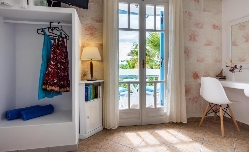 a bedroom with a door leading to a balcony at Orizontes Boutique Studios in Adamantas