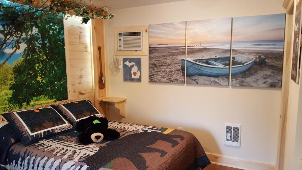 a bedroom with a bed and paintings on the wall at Bear Cove Inn in Saint Ignace