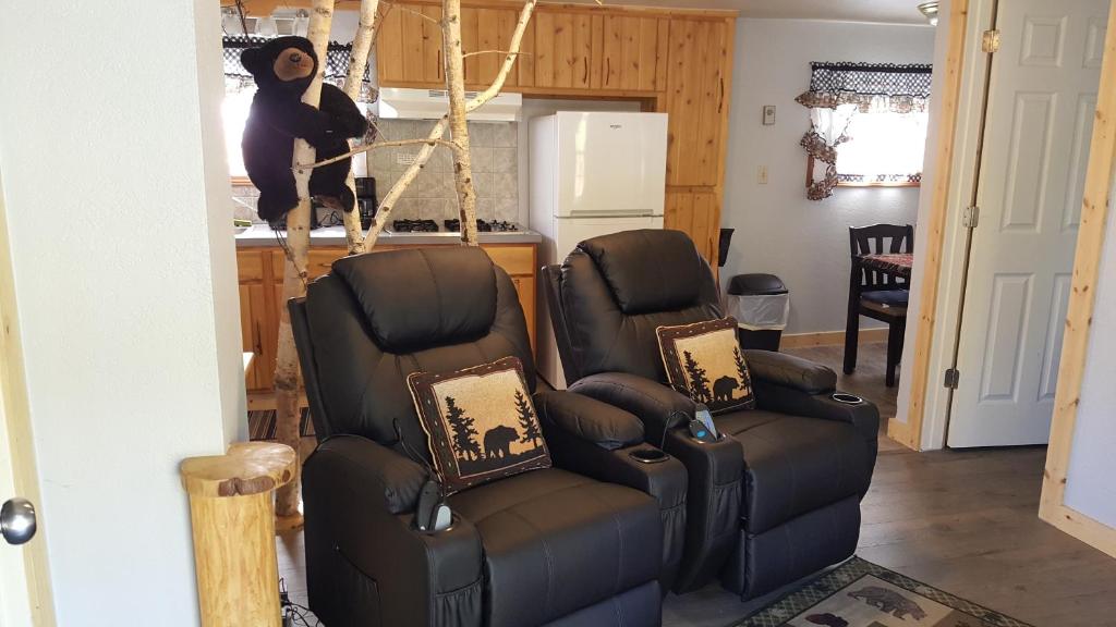 a living room with two chairs and a kitchen at Bear Cove Inn in Saint Ignace