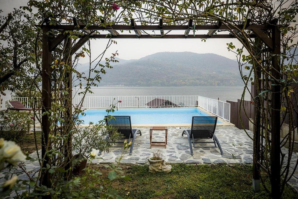 a swimming pool with two chairs and a table at Briza in Orşova