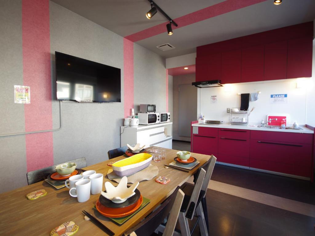 a kitchen with a wooden table and red cabinets at Oak Hotel Edo in Tokyo