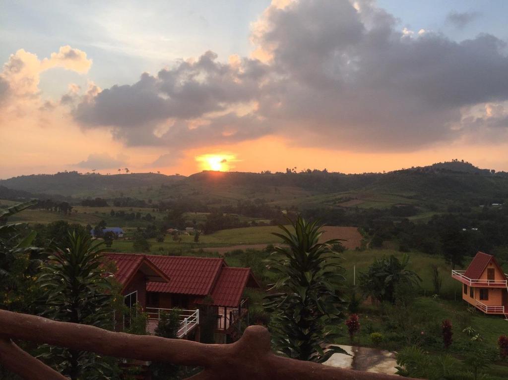 a sunset over a hill with houses and trees at The Memory of Khaokho in Phetchabun