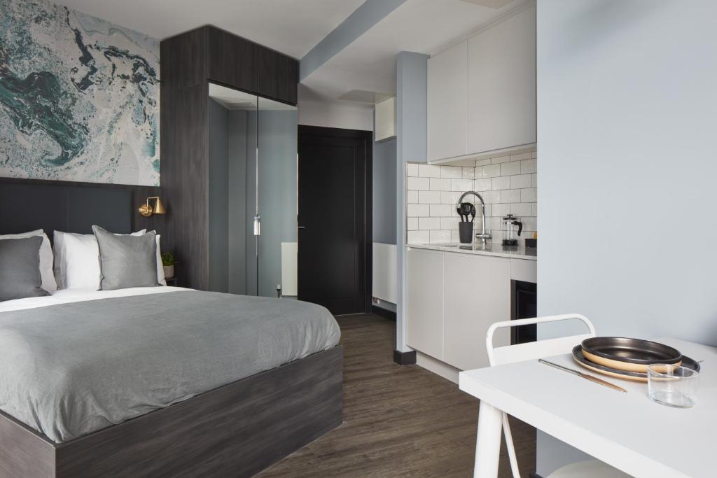 um quarto de hotel com uma cama e uma cozinha em ARK Canary Wharf em Londres