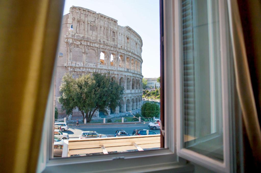 widok z okna na pochyloną wieżę koloseum w obiekcie Royal House w Rzymie