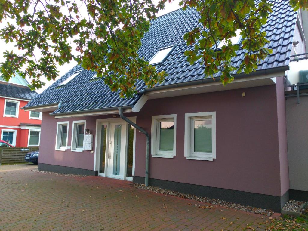 een paars huis met een zwart dak bij Pier 605 - 4 Sterne inklusive POWER WLAN - 2 Parkplätze - Wäschepaket #Bestpreisgarantie# in Zingst