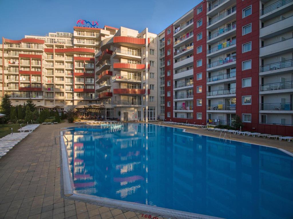 a swimming pool in front of some apartment buildings at Hotel Fenix in Sunny Beach