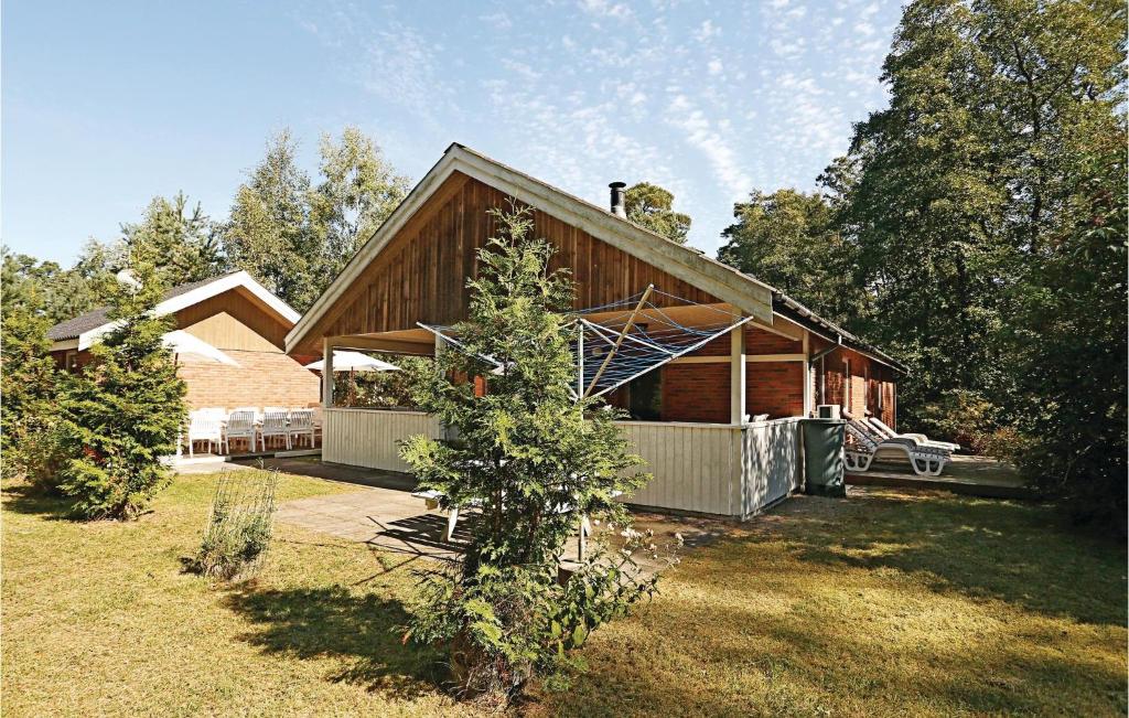 una casa con un árbol delante de ella en Amazing Home In Nex With Wifi, en Spidsegård