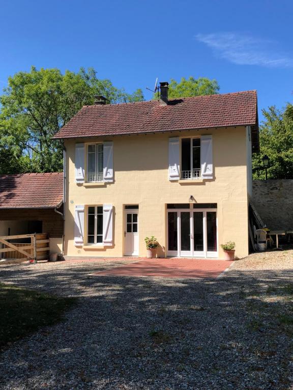 Una gran casa amarilla con una gran entrada en Gite du manoir de l'étang, en Marines