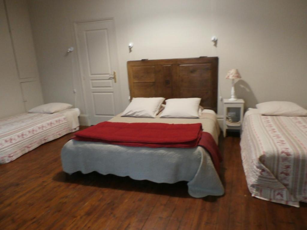 a bedroom with two beds and a wooden floor at La Maison XVIIIe in Moulins