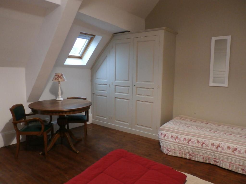 a room with a table and a bed and a window at La Maison XVIIIe in Moulins
