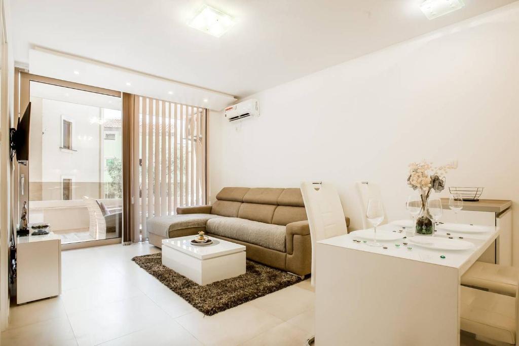 - un salon avec un canapé et une table dans l'établissement Lux Apartment Teodora Rafailovici, à Rafailovici