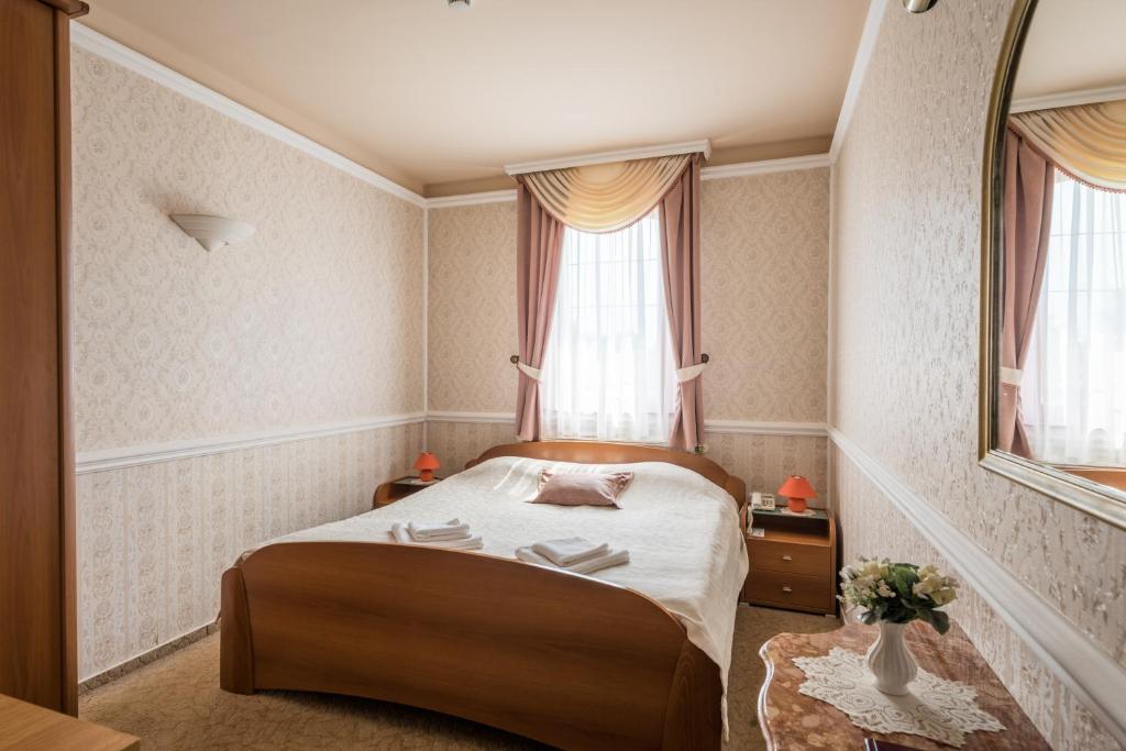 A bed or beds in a room at Hotel Bíbic és Tüskevár Étterem és Horgásztó
