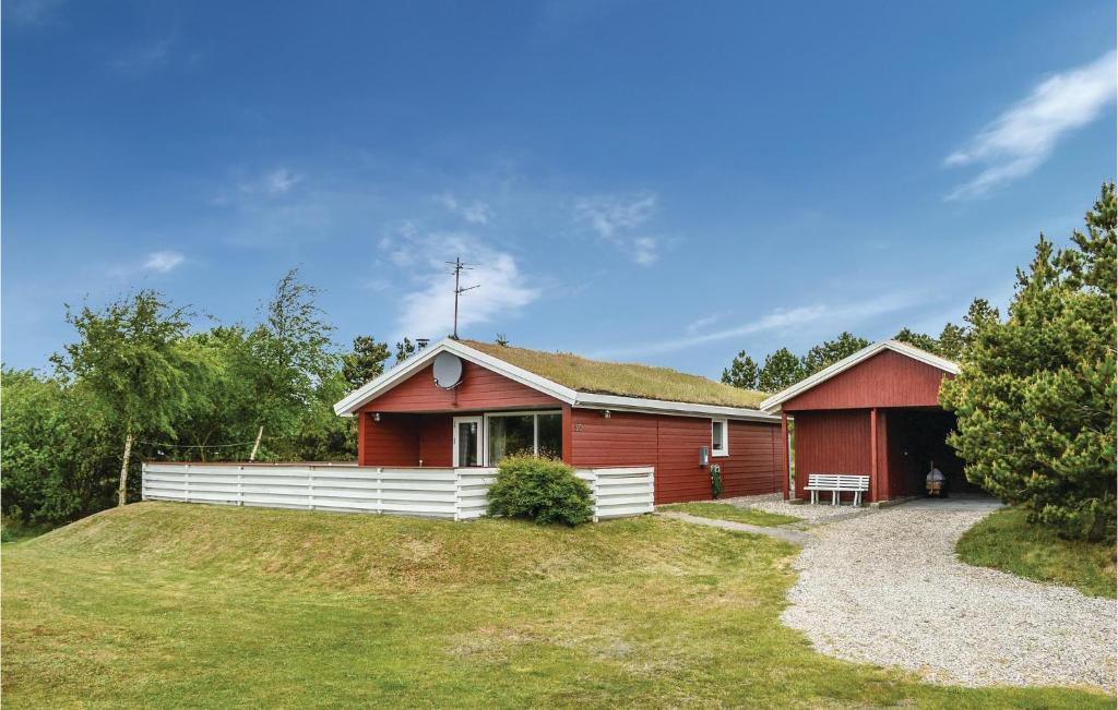 a red house with a grass roof at Holiday Home Ringvejen Rømø Iii in Rømø