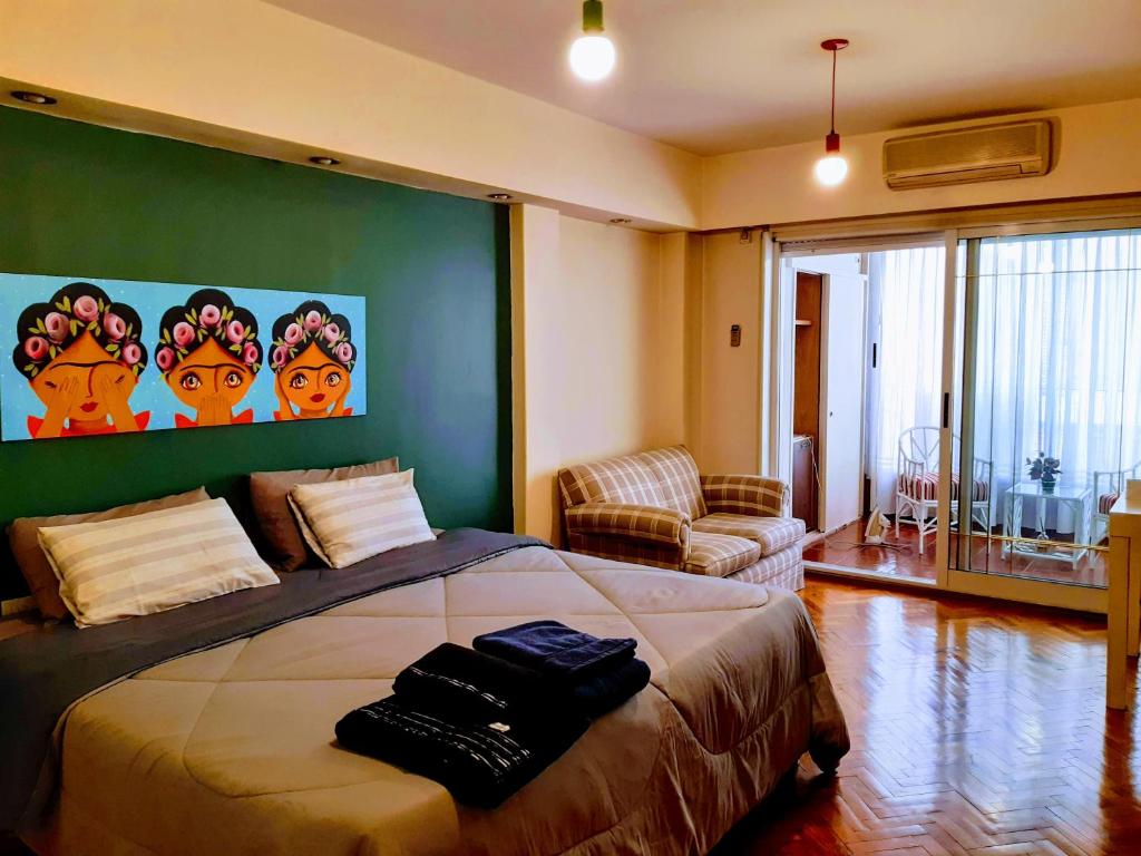 sypialnia z łóżkiem i zieloną ścianą w obiekcie Viva San Martín, Apartamento Luminoso w BuenosAires